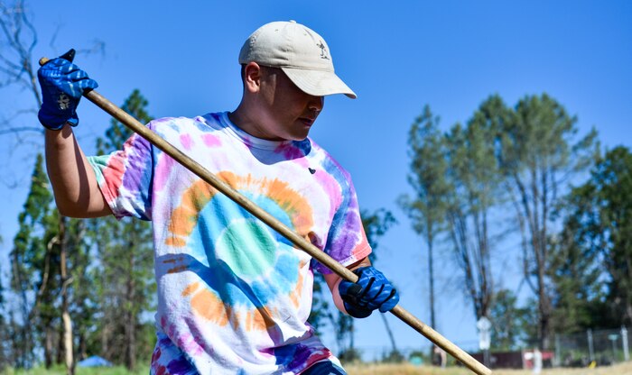 A volunteer Airman rakes brush, June 25, 2021, in Paradise, California.