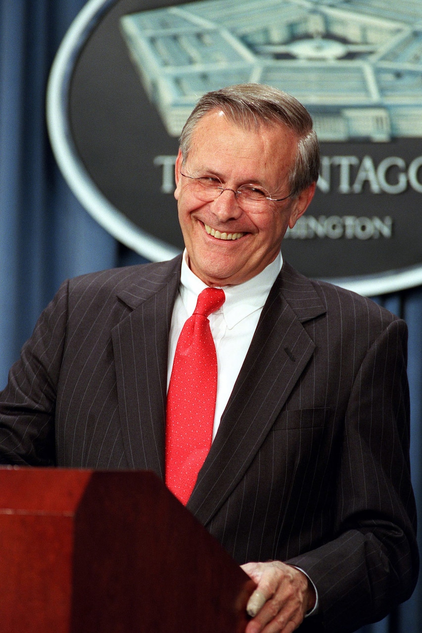 Defense Secretary Donald H. Rumsfeld smiles while standing at a lectern.