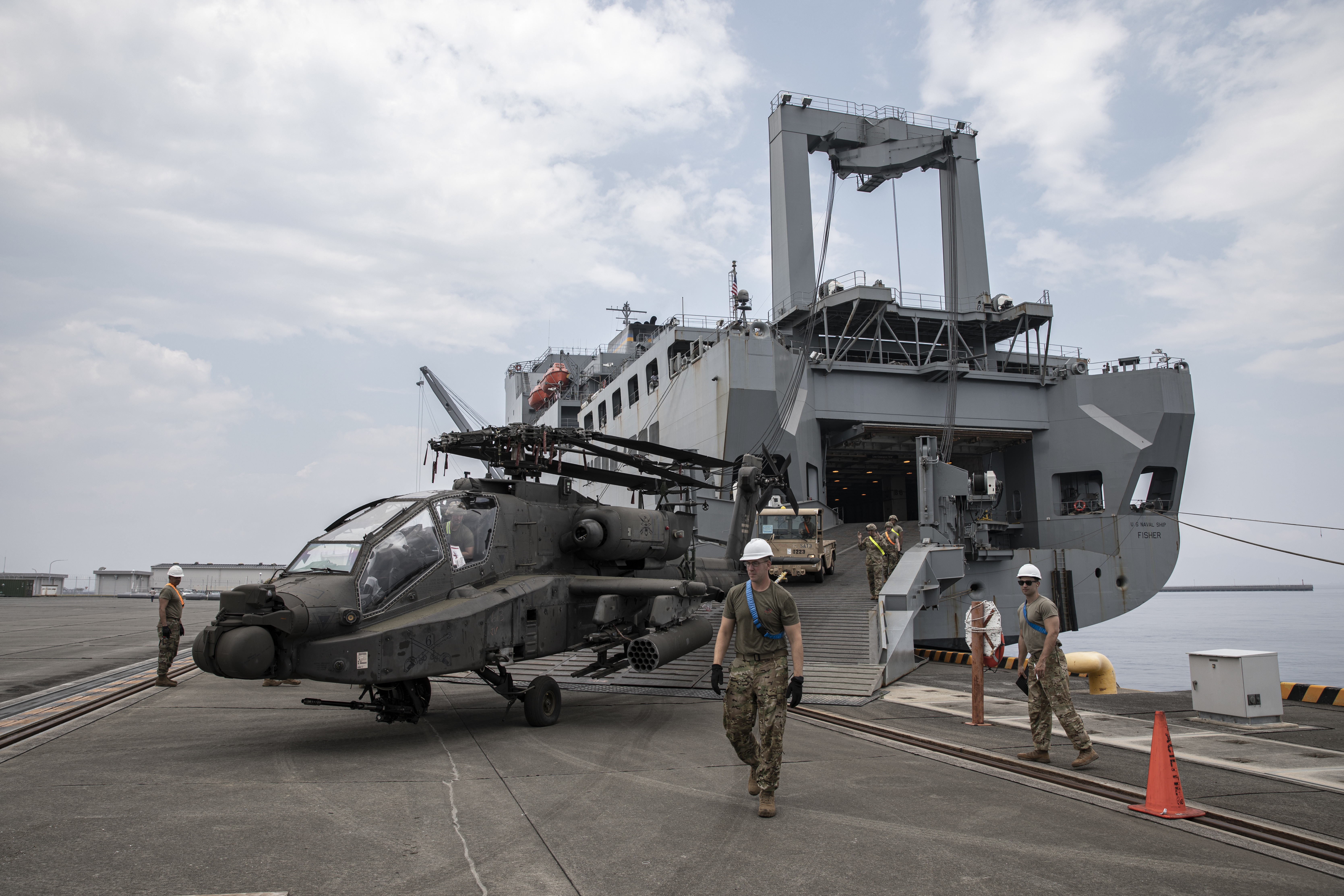 Soldiers assigned to U.S. Army Transportation Battalion direct an AH-64 Apache aboard Marine Corps Air Station Iwakuni, Japan, June 24, 2021, as part of ORIENT SHIELD 21-2 (OS 21-2).