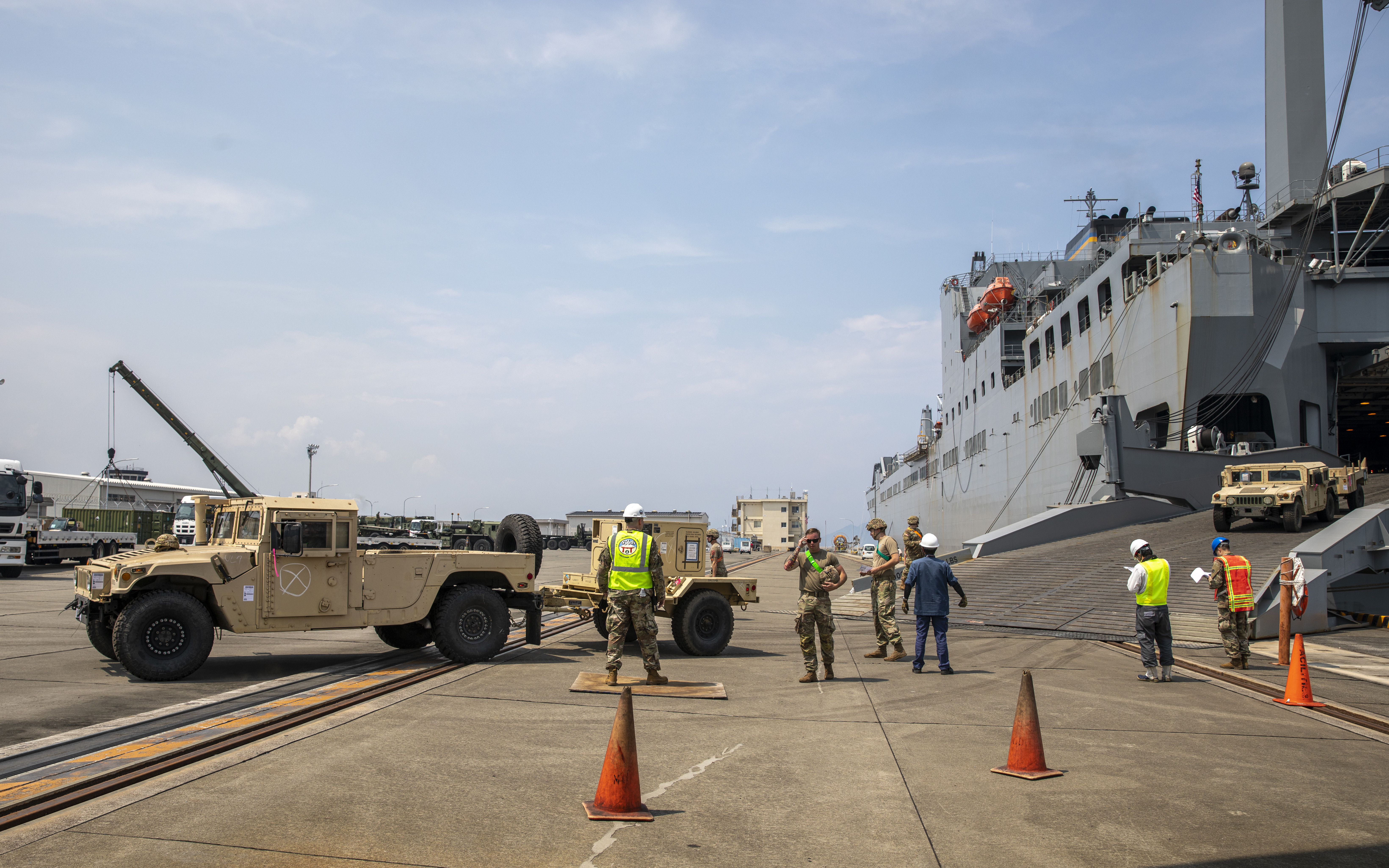 Soldiers unload cargo from the Bob Hope-class roll on roll off vehicle cargo ship USNS Fisher (T-AKR-301) aboard Marine Corps Air Station Iwakuni, Japan, June 24, 2021