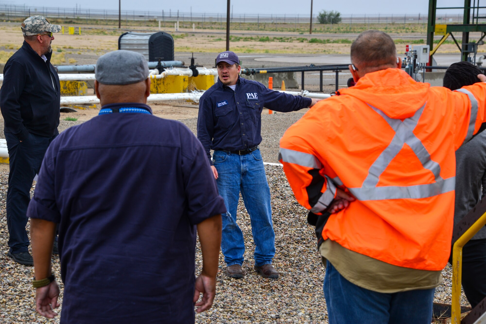 Man explains spill prevention protocol to a small group of people at Kirtland, AFB.