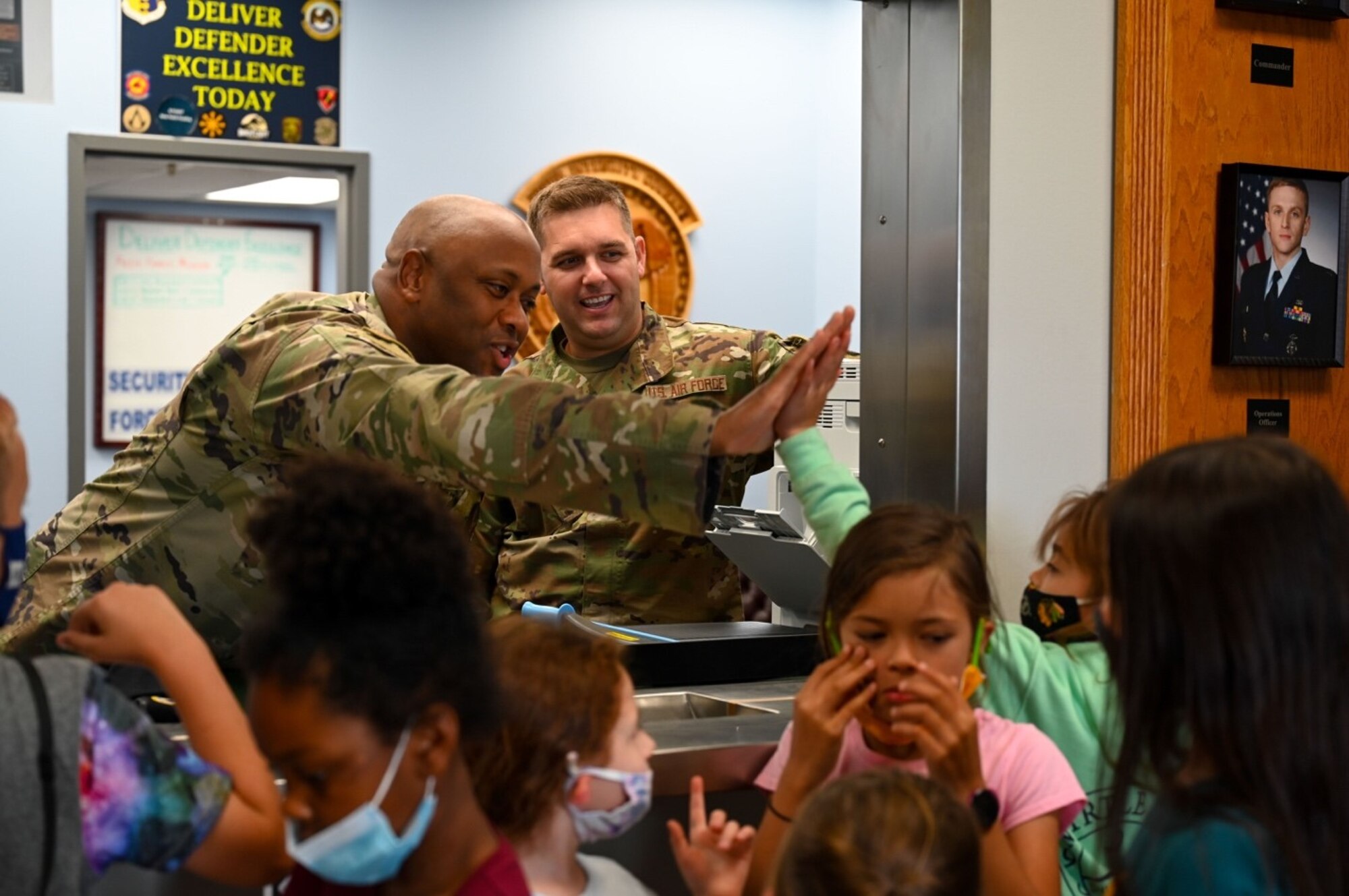 Lt. Col. David Herndon, the 28th Security Forces Squadron commander, gives a high five to one of the children enrolled in the School Age Care program at Ellsworth Air Force Base, S.D., June 25, 2021.