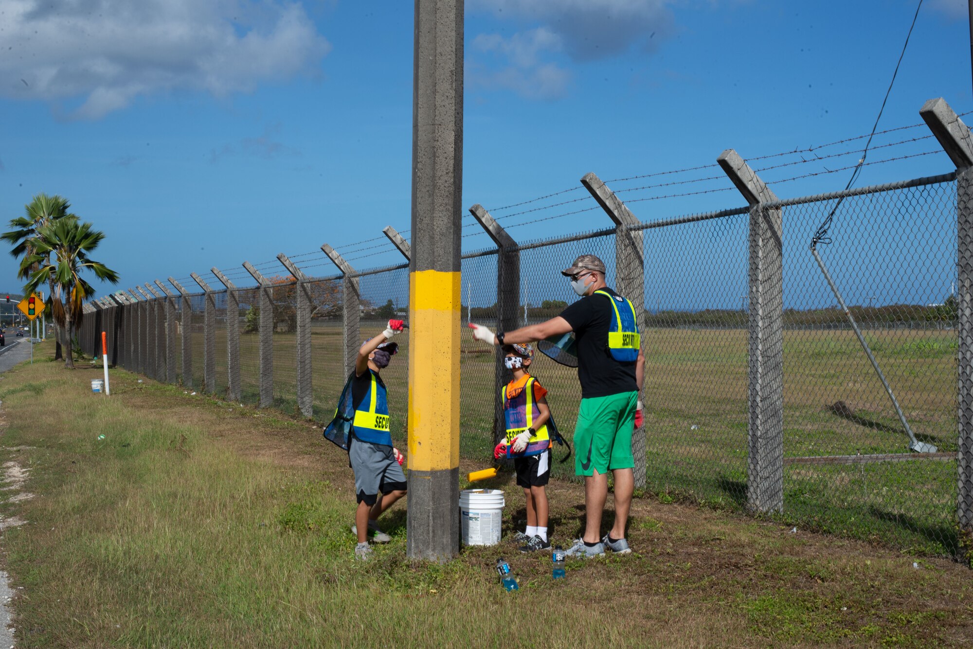 Master Sgt. Seth Russel, 36th Operational Medical Readiness Squadron, and his sons, Kole and Keizo, paint a power pole in Mongmong-Toto-Maite, Guam, Feb. 27, 2021.