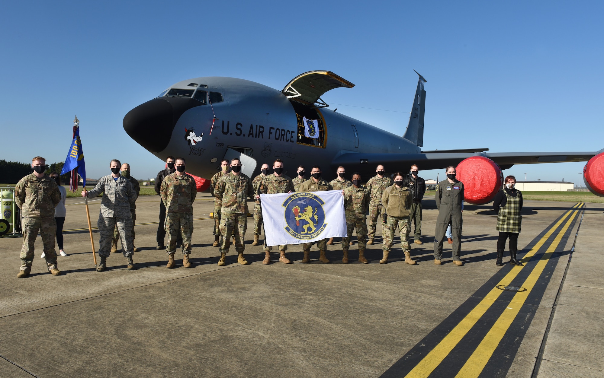 Leadership, Airmen and civilians from the 100th Operations Support Squadron pose for a photo in front of their newly sponsored KC-135 Stratotanker aircraft, with World War II heritage nose art “Wolff Pack” at Royal Air Force Mildenhall, England, Feb. 26, 2021. As part of a new “Adopt-a-Jet” program, squadrons at RAF Mildenhall will begin sponsoring a jet bearing a specific heritage nose art, in an effort to reconnect with 100th Bombardment Group history. (U.S. Air Force photo by Karen Abeyasekere)