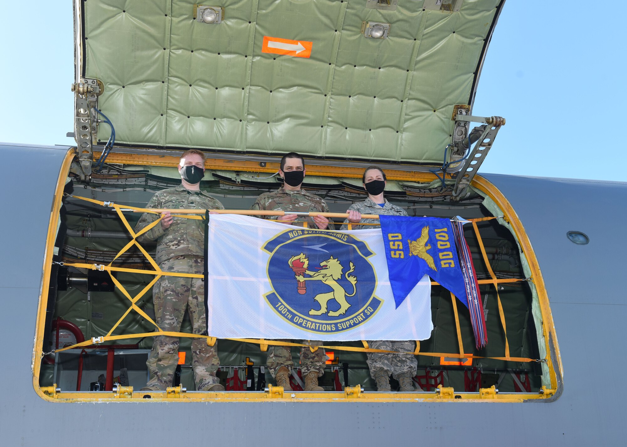 U.S. Air Force Lt. Col. Brandon Lauret, left, 100th Operations Support Squadron commander; Senior Master Sgt. Joshua Pollard, center, 100th OSS superintendent, and Master Sgt. Erin Barger, 100th Operations Group first sergeant, pose for a photo with a 100th OSS flag and guidon while on board a KC-135 Stratotanker aircraft at Royal Air Force Mildenhall, England, Feb. 26, 2021. The 100th OSS now officially sponsors aircraft 63-7999, with the heritage nose art “Wolff Pack,” named in honor of Lt. Robert Wolff, former B-17 Flying Fortress pilot with the 418th Bomb Squadron, 100th Bombardment Group, who flew his first combat mission out of Thorpe Abbotts. (U.S. Air Force photo by Karen Abeyasekere)