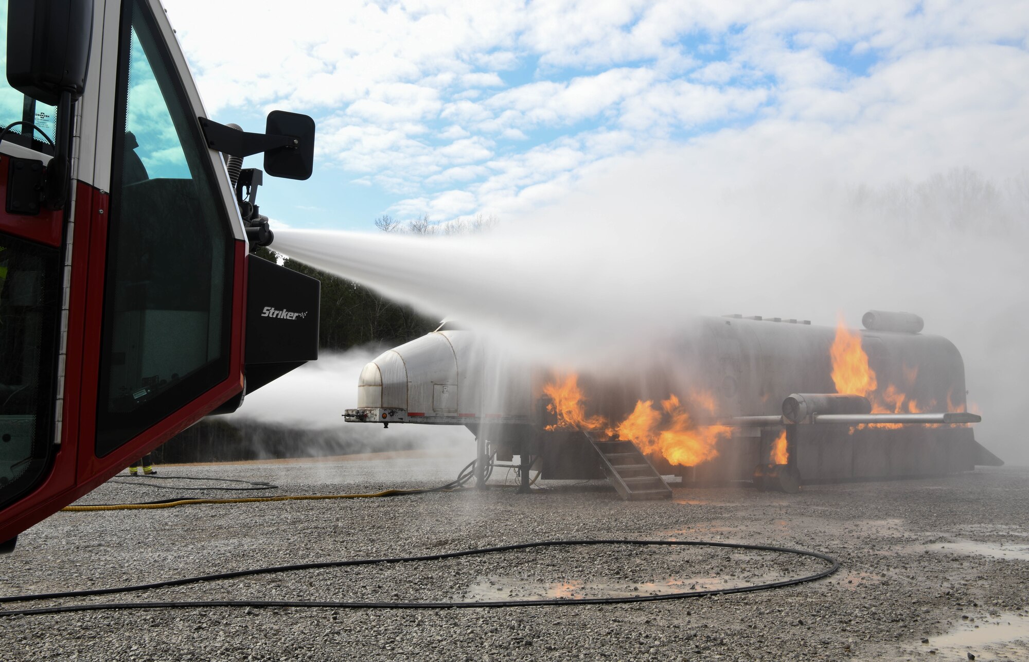 Water pours onto a training simulator from vehicle-mounted nozzles as Arnold Air Force Base Fire and Emergency Services personnel train Feb. 10, 2021, on aircraft rescue and firefighting techniques at the base. (U.S. Air Force photo by Jill Pickett)
