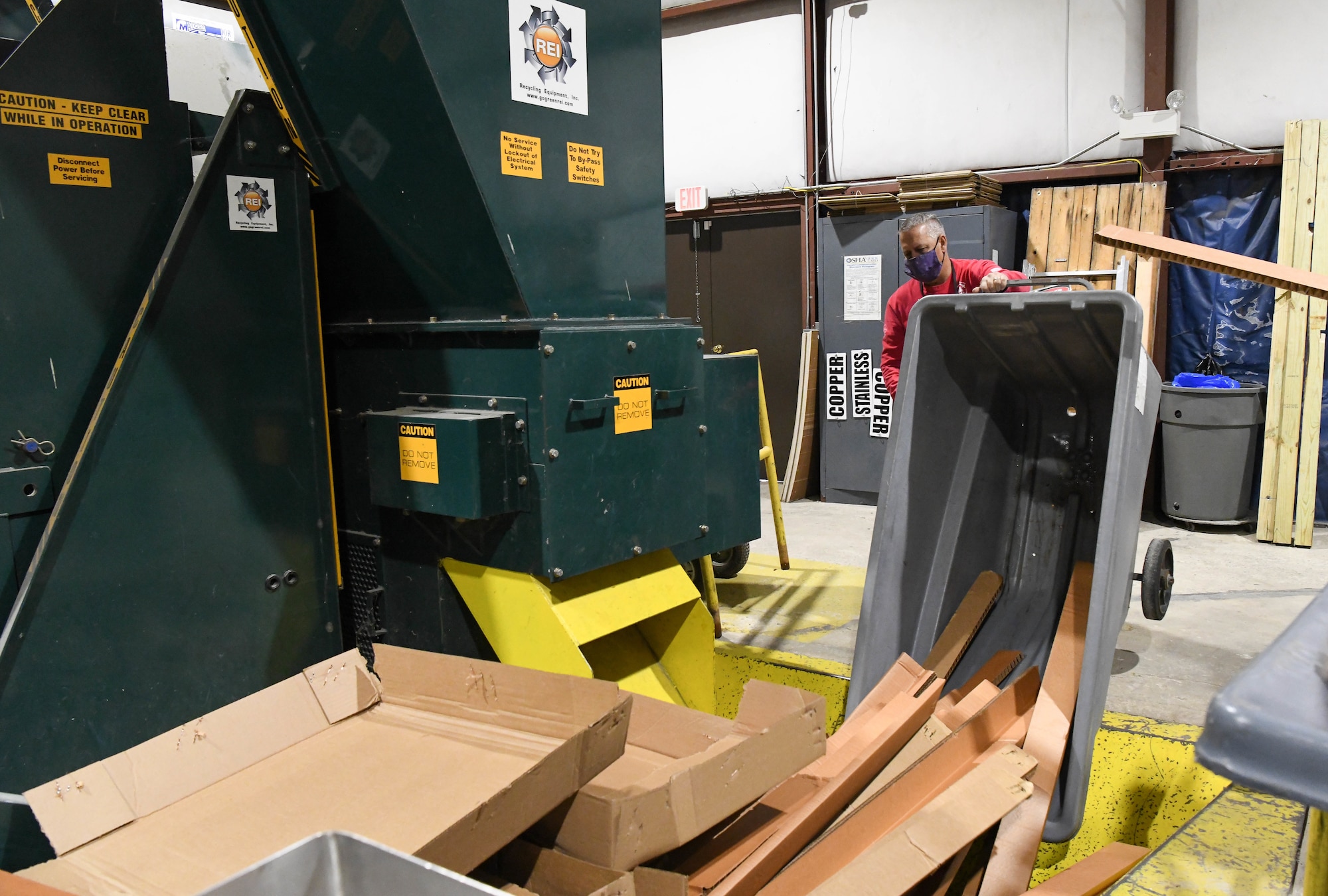 Bud Schell, a motor vehicle operator for the Arnold Air Force Base Services Recycling Program, tips a bin of cardboard onto a conveyor to be fed into a baler in the Recycling Facility at Arnold AFB, Tenn., Feb. 11, 2021. (U.S. Air Force photo by Jill Pickett)