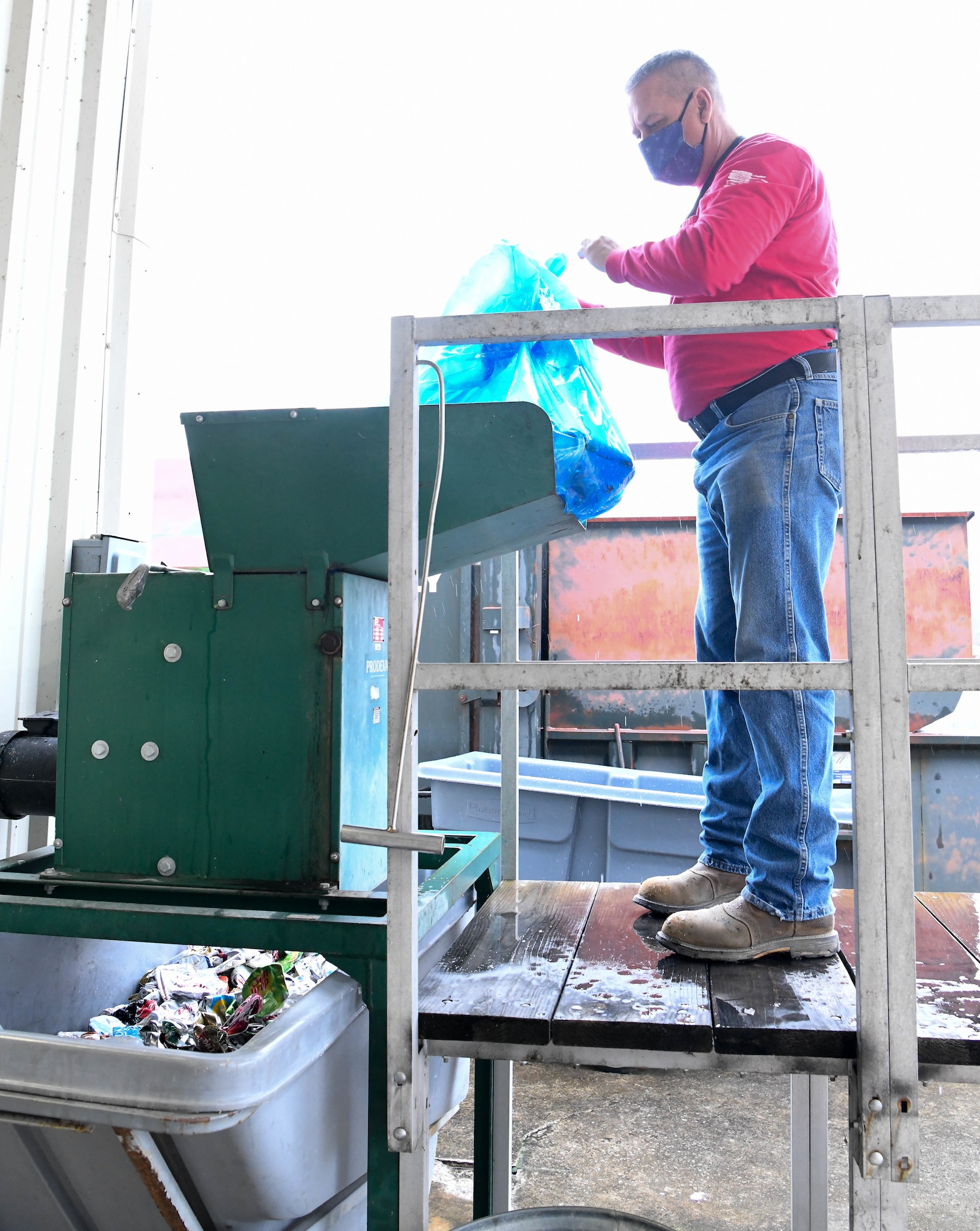 Bud Schell, a motor vehicle operator for the Arnold Air Force Base Services Recycling Program, empties a bag of aluminum cans into a crusher outside of the Recycling Facility at Arnold AFB, Tenn., Feb. 11, 2021. (U.S. Air Force photo by Jill Pickett)
