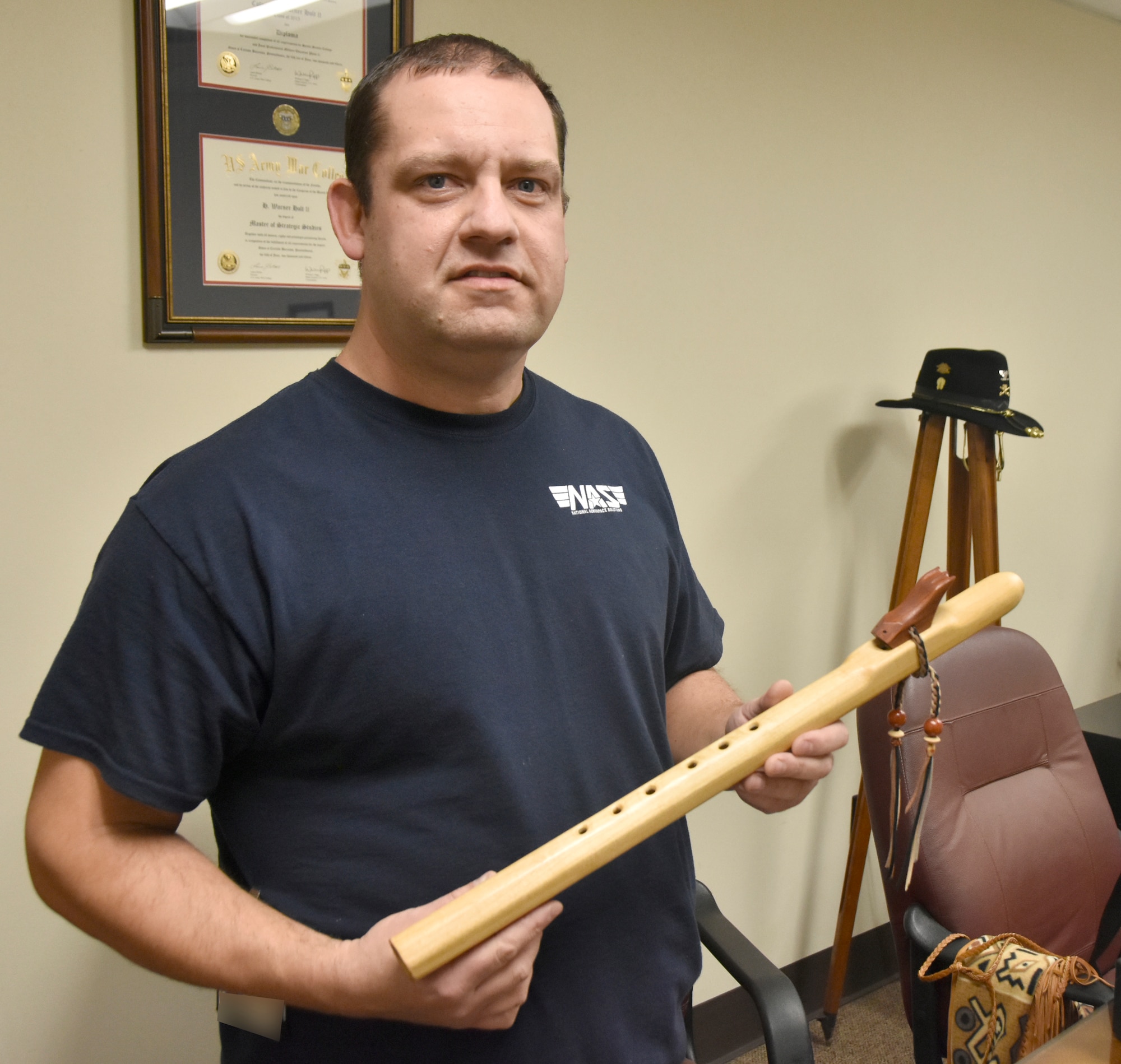 Kevin Ashley, an inside machinist in the Arnold Engineering Development Complex Model and Machine Shop at Arnold Air Force Base, Tenn., shows one of the Native American he has made over the years. Ashley began playing Native American flute around 20 years ago. (U.S. Air Force photo by Bradley Hicks) (This image has been altered by obscuring badges for security purposes.)