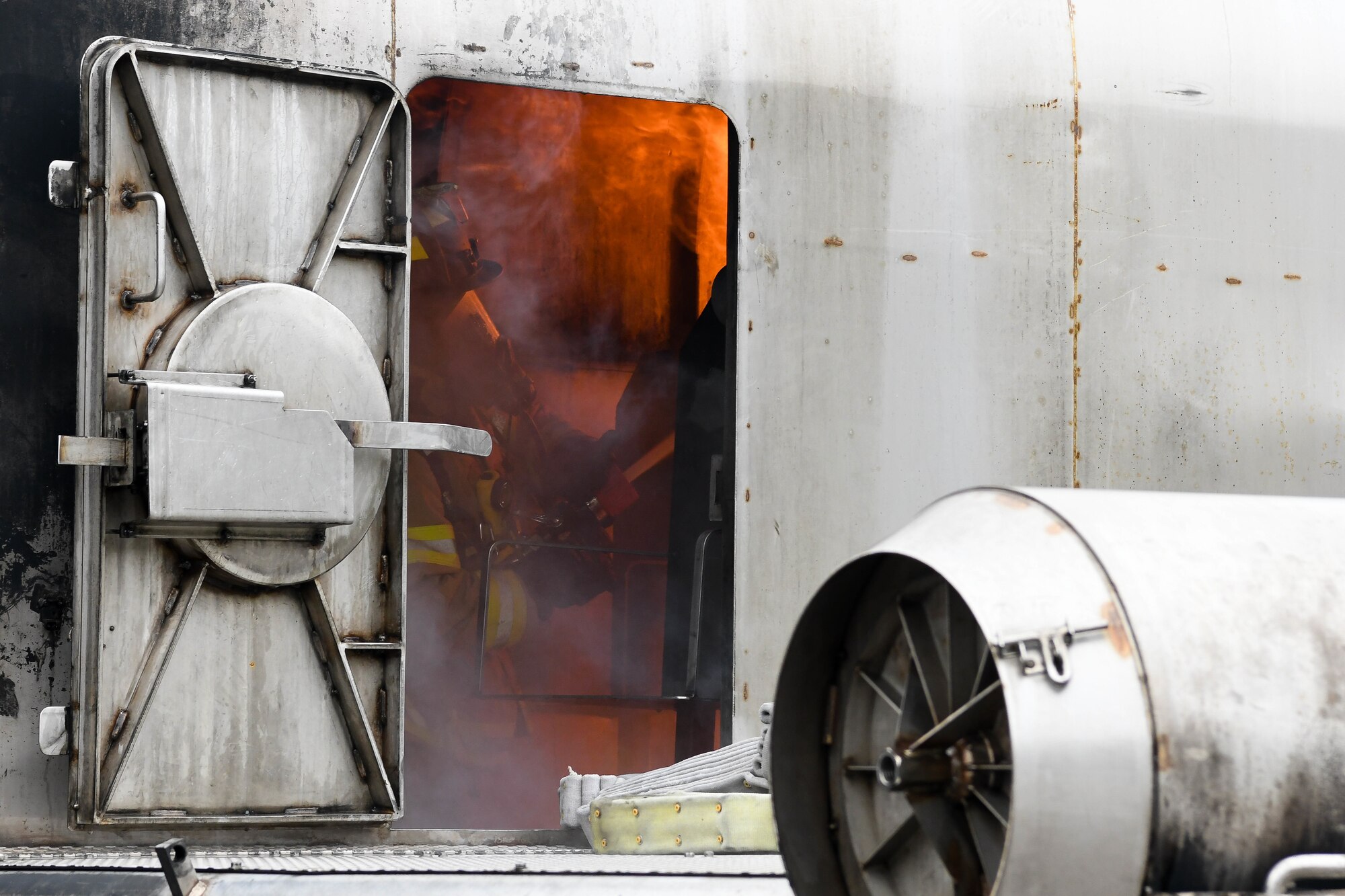 An Arnold Air Force Base Fire and Emergency Services firefighter attacks fires as he and a partner work their way through the mock aircraft while training, Feb. 9, 2021, at Arnold AFB, Tenn. During interior attack training, firefighters battled fires, gained control of systems from the cockpit, ventilated smoke and searched for mock victims. (U.S. Air Force photo by Jill Pickett)