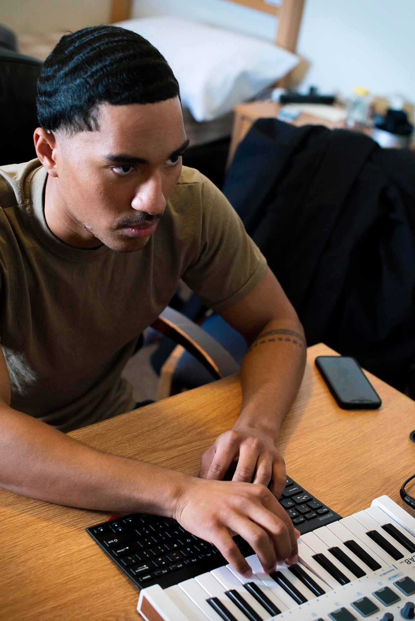 Airman 1st Class Josiah Beecham, 27th Special Operations Aircraft Maintenance Squadron electrical and environmental apprentice, records himself playing notes on a keyboard in his dorm room on Cannon AFB N.M., February 15th, 2021. Beecham uses a variety of electronic equipment to make music right on his laptop. (U.S. Air Force photo by Airman 1st Class Christopher Storer)