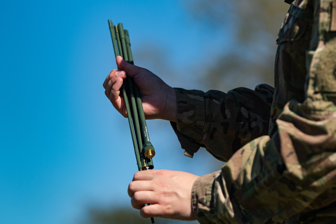A photo of an Airman collapsing an antenna