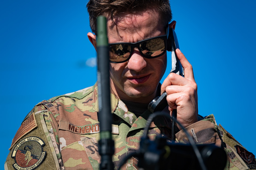 A photo of an Airman using a radio