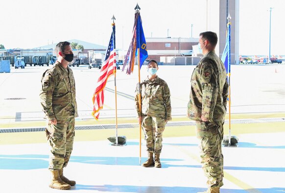 Two uniformed personnel stand across from each other during ceremony.