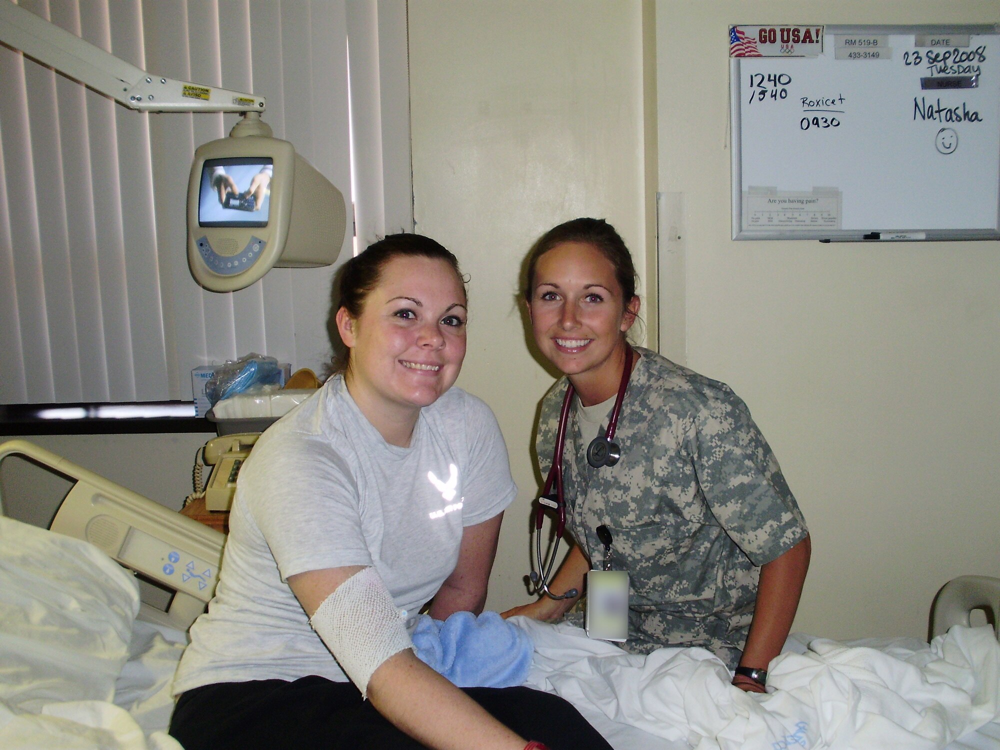 Two people pose for photo in a hospital room
