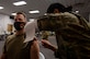 Col. Stephen R. Jones receives COVID-19 vaccination in his left arm from a medical technician.