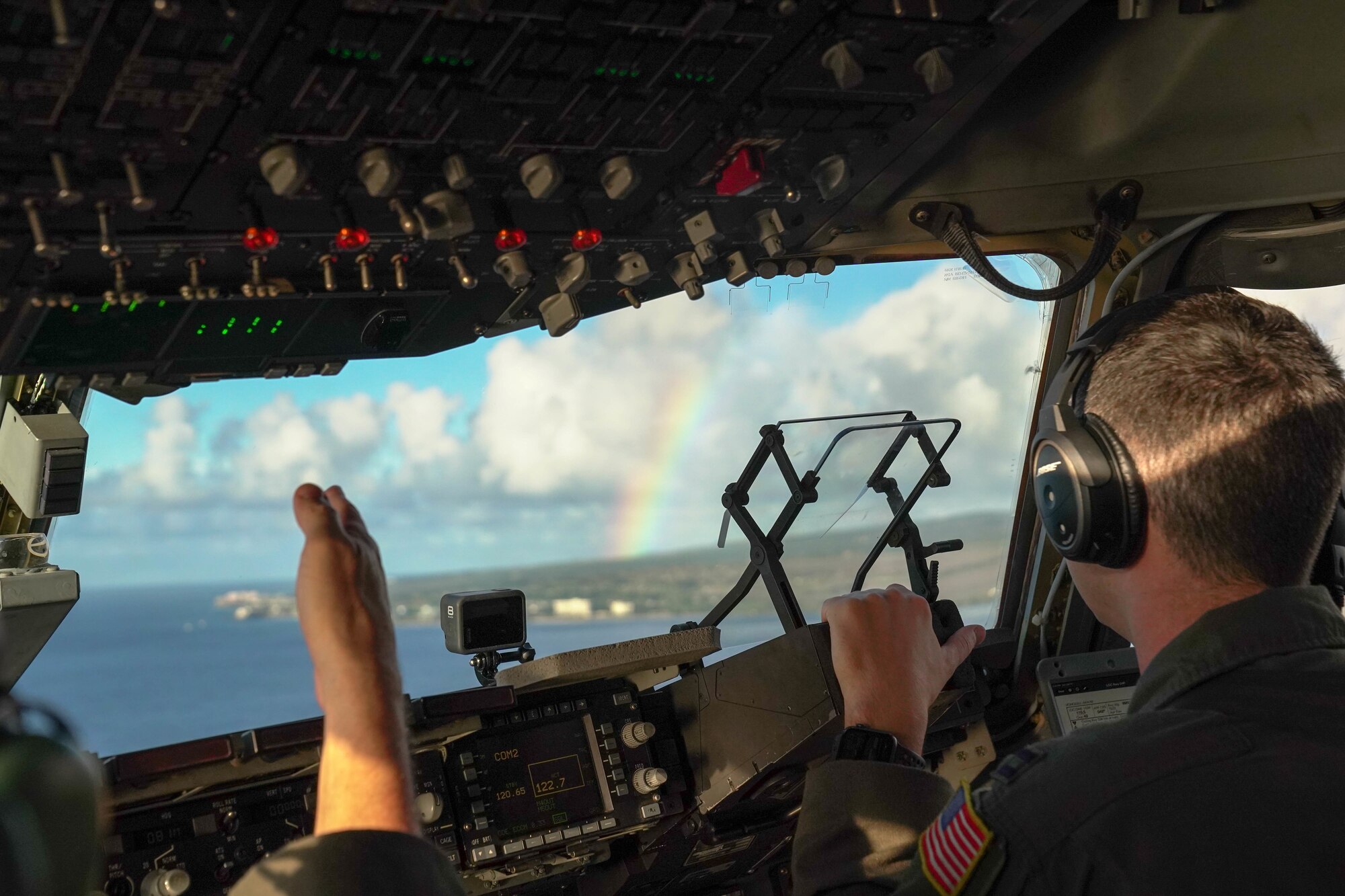 Col. Scott Berndt, 15th Wing Operations Group commander, points out a rainbow to Capt. Garrison Boone, 535th Airlift Squadron pilot, during a flight training exercise around the Hawaiian Islands, Jan. 31, 2021. The C-17 Globemaster III can perform many different flight maneuvers including tactical airlift and airdrop missions. (Air Force photo by Airman 1st Class Makensie Cooper)
