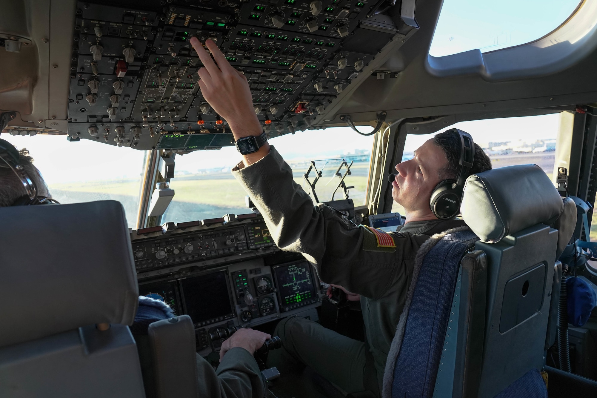 Capt. Garrison Boone, 535th Airlift Squadron pilot, adjusts controls in the cockpit to prepare for the final approach to land at Joint Base Pearl Harbor-Hickam, Hawaii, Jan. 31, 2021. The 535th AS conducted a go-around mission over Maui, a training exercise where the landing is aborted during the final approach.  (Air Force photo by Airman 1st Class Makensie Cooper)