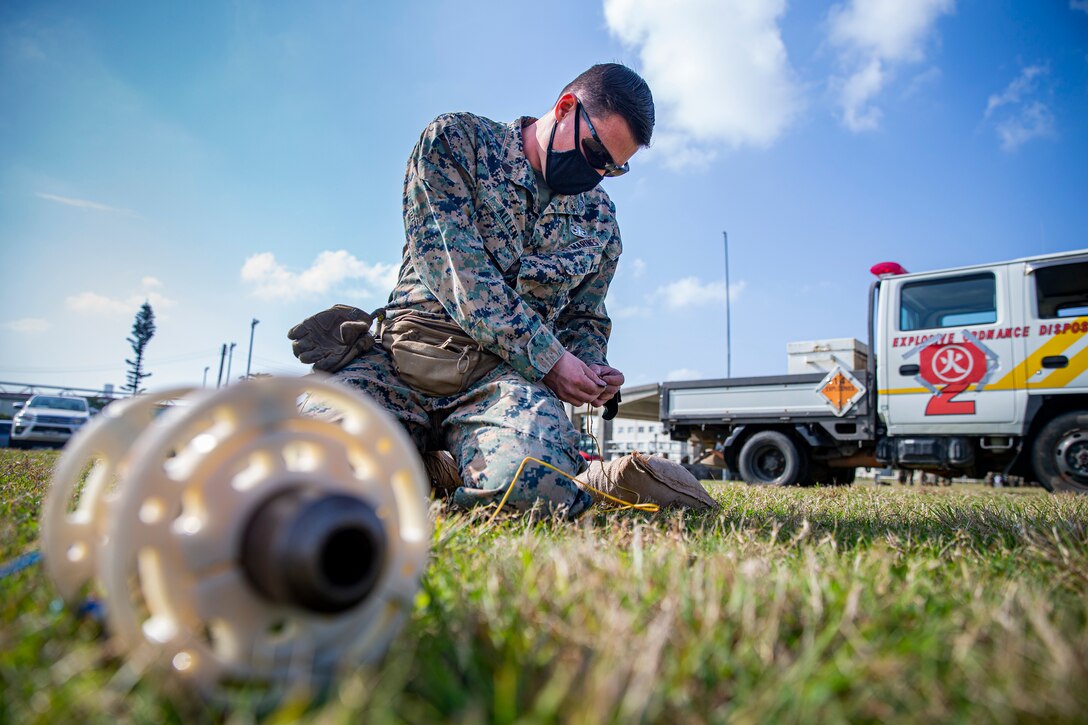 U.S. Marine Corps Sgt. Timothy Allen, an explosive ordnance disposal (EOD) technician with Marine Corps Base Camp Butler EOD, creates a circuit using firing wire on Camp Hansen, Okinawa, Japan, Feb. 25, 2021. EOD technicians and artillery Marines conducted normal M777 Howitzer firing procedures, however, dummy rounds were intentionally lodged in the 16.7 ft. barrel of the weapon system so each unit could demonstrate their extraction techniques. Allen is a native of Warsaw, Missouri. (U.S. Marine Corps photo by Lance Cpl. Alex Fairchild)