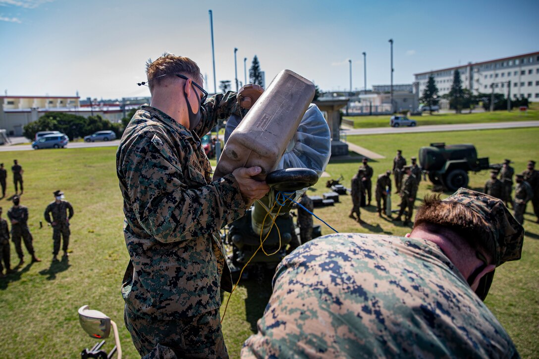 U.S. Marine Corps Sgt. Adam Koffron, an explosive ordnance disposal (EOD) technician with 9th Engineer Support Battalion, 3rd Marine Logistics Group, loads water into an M777 Howitzer to create hydraulic pressure for stuck dummy round removal on Camp Hansen, Okinawa, Japan, Feb. 25, 2021. EOD technicians and artillery Marines conducted normal M777 Howitzer firing procedures, however, dummy rounds were intentionally lodged in the 16.7 ft. barrel of the weapon system so each unit could demonstrate their extraction techniques. Koffron is a native of Mount Vernon, Iowa