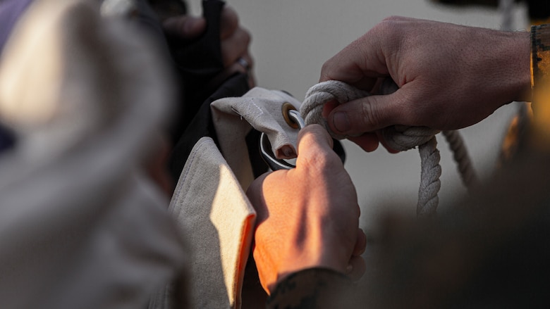 U.S. Marines fasten a Prisoner of War flag to a flagpole on Camp Foster, Okinawa, Japan, Jan. 13, 2021. The Marines were performing their daily duties of executing a ceremonial flag raising alongside Japanese Security Guards. Performing a daily colors ceremony with the host nation symbolizes the cooperation and joint effort of American and Japanese forces throughout Japan. . (U.S. Marine Corps Photo by Cpl. Christopher A. Madero)