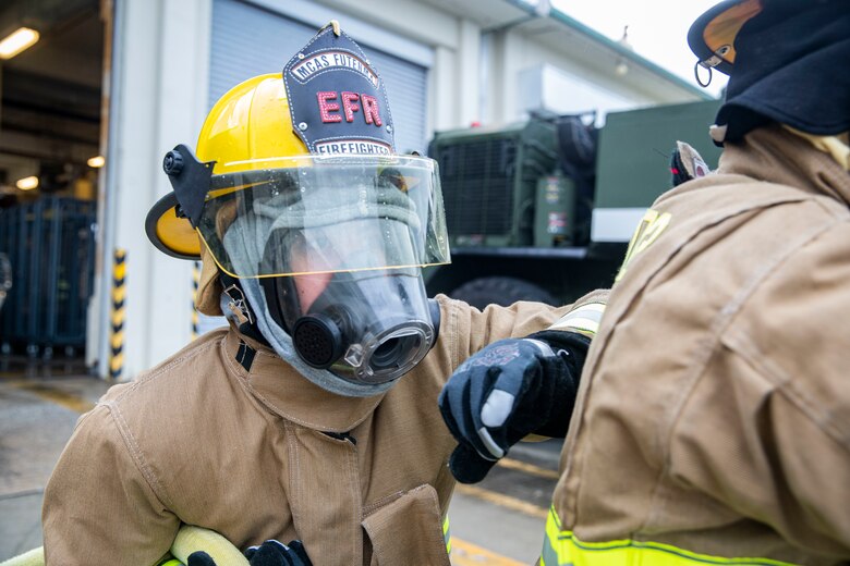 U.S. Marine Corps Lance Cpl. Louis Nichols, an expeditionary firefighting and rescue specialist with Headquarters and Support Battalion, helps carry a hose during a rapid response drill at Marine Corps Air Station Futenma, Okinawa, Japan, Jan. 7, 2020. The drill is designed to make Marines faster and more efficient at responding to emergencies.
