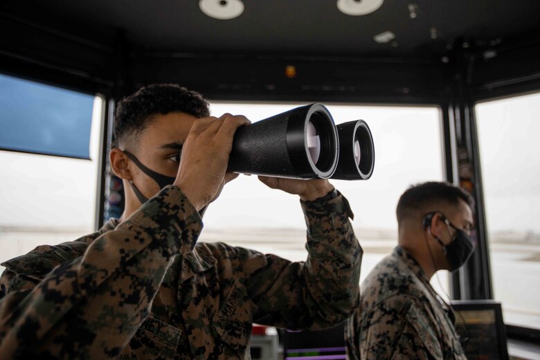U.S. Marine Corps Cpl. Tristan Whitney, an air traffic control specialist with Headquarters and Headquarters Squadron, Marine Corps Air Station Futenma, visually scans the airfield surface area on MCAS Futenma, Okinawa, Japan, Jan. 7, 2021. Air traffic controllers aboard MCAS Futenma are responsible for the safe and expeditious flow of air traffic as well as the safety and security of the mission of aviation assets.