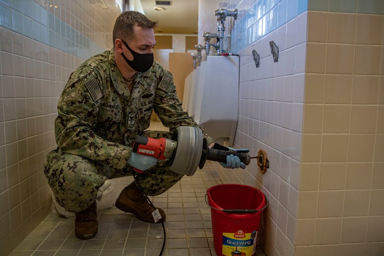 U.S. Navy Petty Officer 2nd Class Kody Schwartz, a utilitiesman second class with U.S. Navy Seabees, Headquarters and Support Battalion, fixes a broken urinal at Marine Corps Air Station Futenma, Okinawa, Japan, Jan. 29, 2021. Schwartz is utilities maintenance, a Marine Corps Instructor of Water Survival, and Sexual Assault Prevention and Response advocate which makes him a vital asset to Marine Corps Installations Pacific. Schwartz is native to Hutchison, Minnesota. (U.S. Marine Corps photo by Lance Cpl. Zachary Larsen)