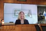 A woman celebrates her retirement remotely via a virtual screen.