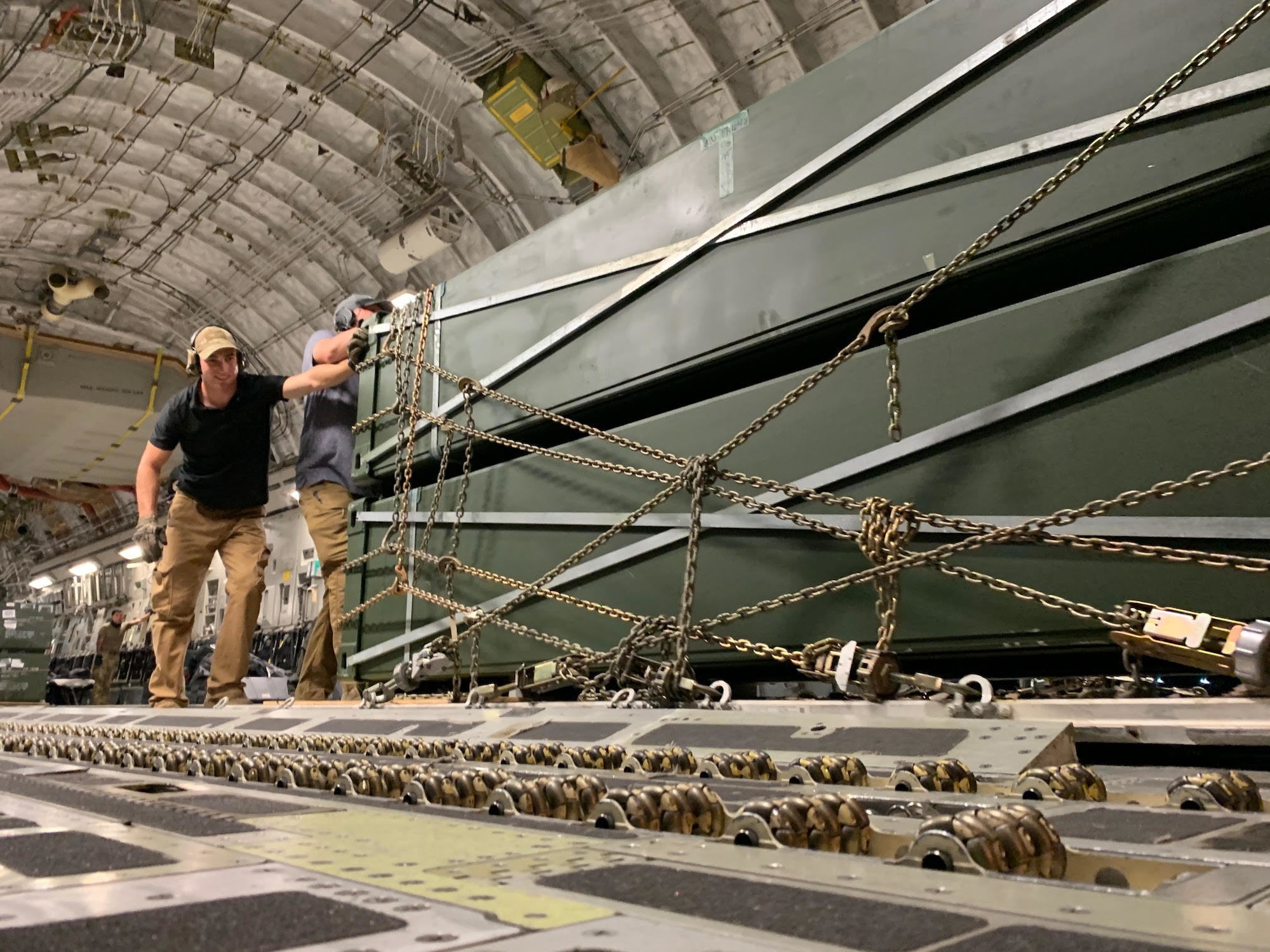 U.S. Air Force Airmen assigned to the 435th Air Expeditionary Wing push cargo off a U.S Air Force C-130J Super Hercules aircraft during Operation Octave Quartz