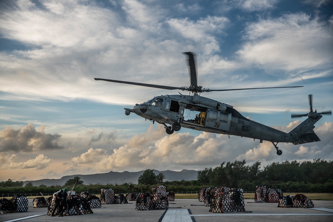 U.S. Marines and Navy Sailors conduct external lifts for a vertical replenishment of the aircraft carrier USS Theodore Roosevelt, Naval Base Guam, Feb. 25.