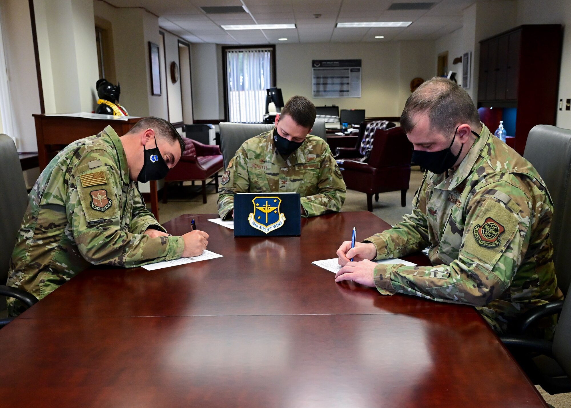 A group of people sign a form