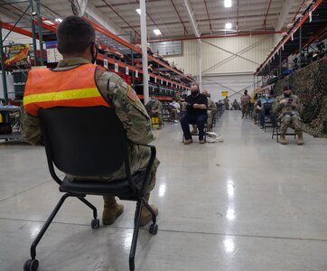 Military and civilian personnel wait the required 15 to 30 minutes after receiving their COVID-19 vaccination shot.