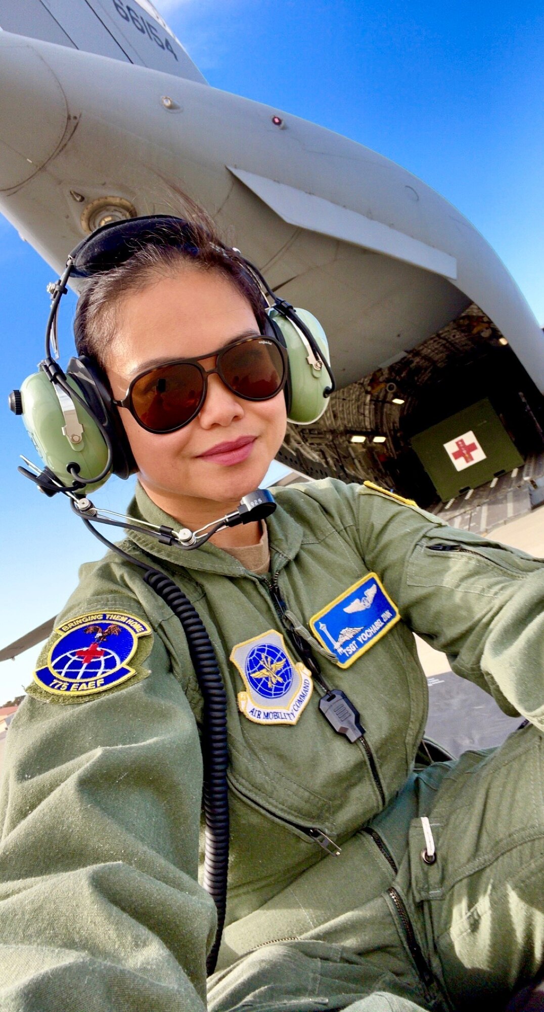 An Air Force Reserve medical professional takes photo near aircraft carrying medical equipment.