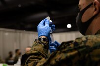 A U.S. Navy Sailor, assigned to Combat Logistics Battalion 22 (CLB-22), prepares a COVID-19 vaccine during the state-run, federally-supported COVID-19 Community Vaccination Center at the Pennsylvania Convention Center in Philadelphia, March 1, 2021.