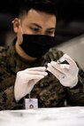 U.S. Navy Petty Officer 2nd Class Hendrick Lara, a hospital corpsman from Menifee, California, assigned to Combat Logistics Battalion 22 (CLB-22), prepares a COVID-19 vaccine during the setup of the state-run, federally-supported COVID-19 Community Vaccination Center at the Pennsylvania Convention Center in Philadelphia, March 1, 2021.