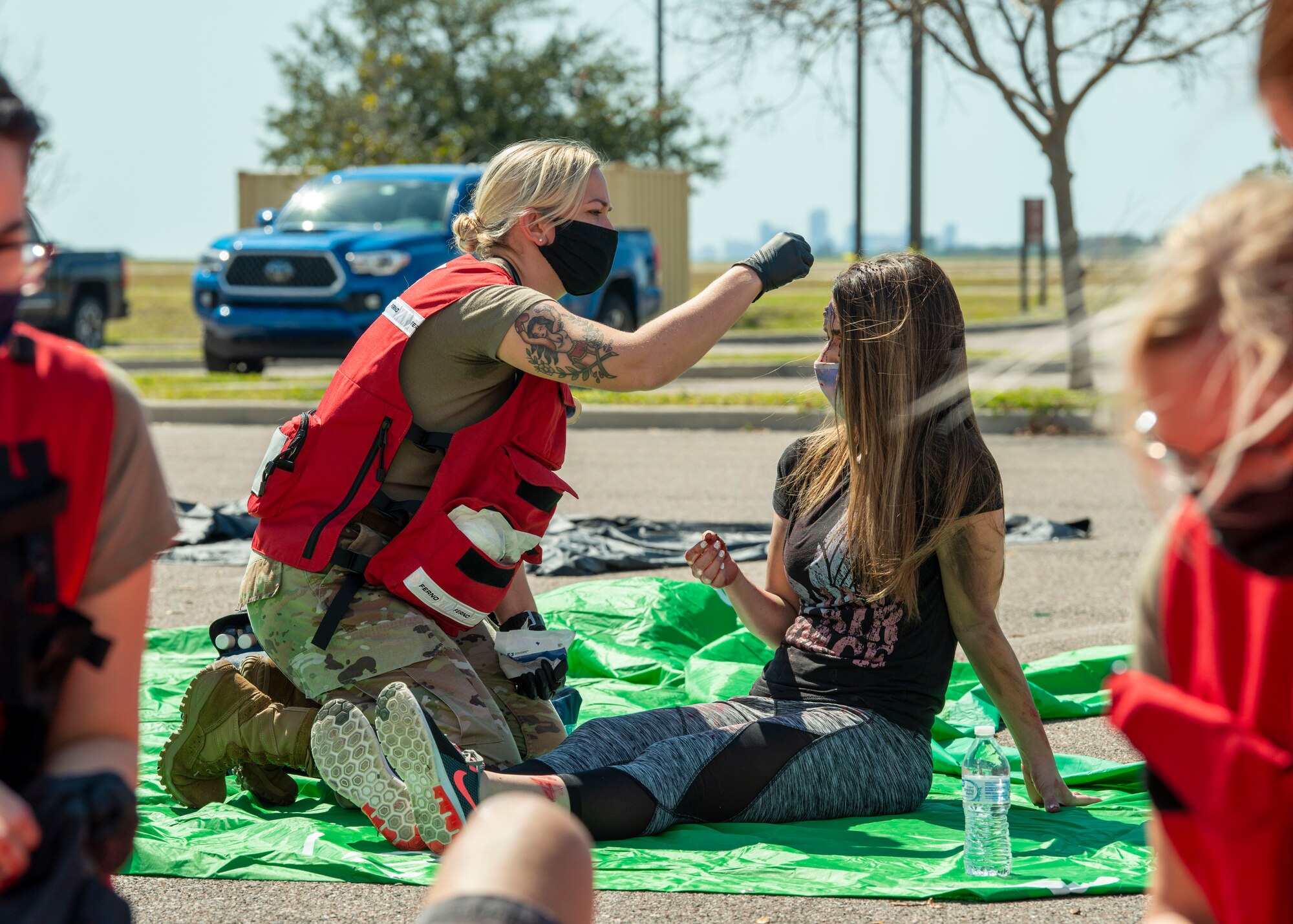 A 6th Medical Group emergency responder places a bandage on a simulated injured volunteers head during training exercise Ready EAGLE at MacDill Air Force Base, Fla., Feb. 25, 2021. The blood and injuries in this exercise were created using moulage techniques and are not real. (U.S. Air Force photograph by Airman 1st Class David D. McLoney)