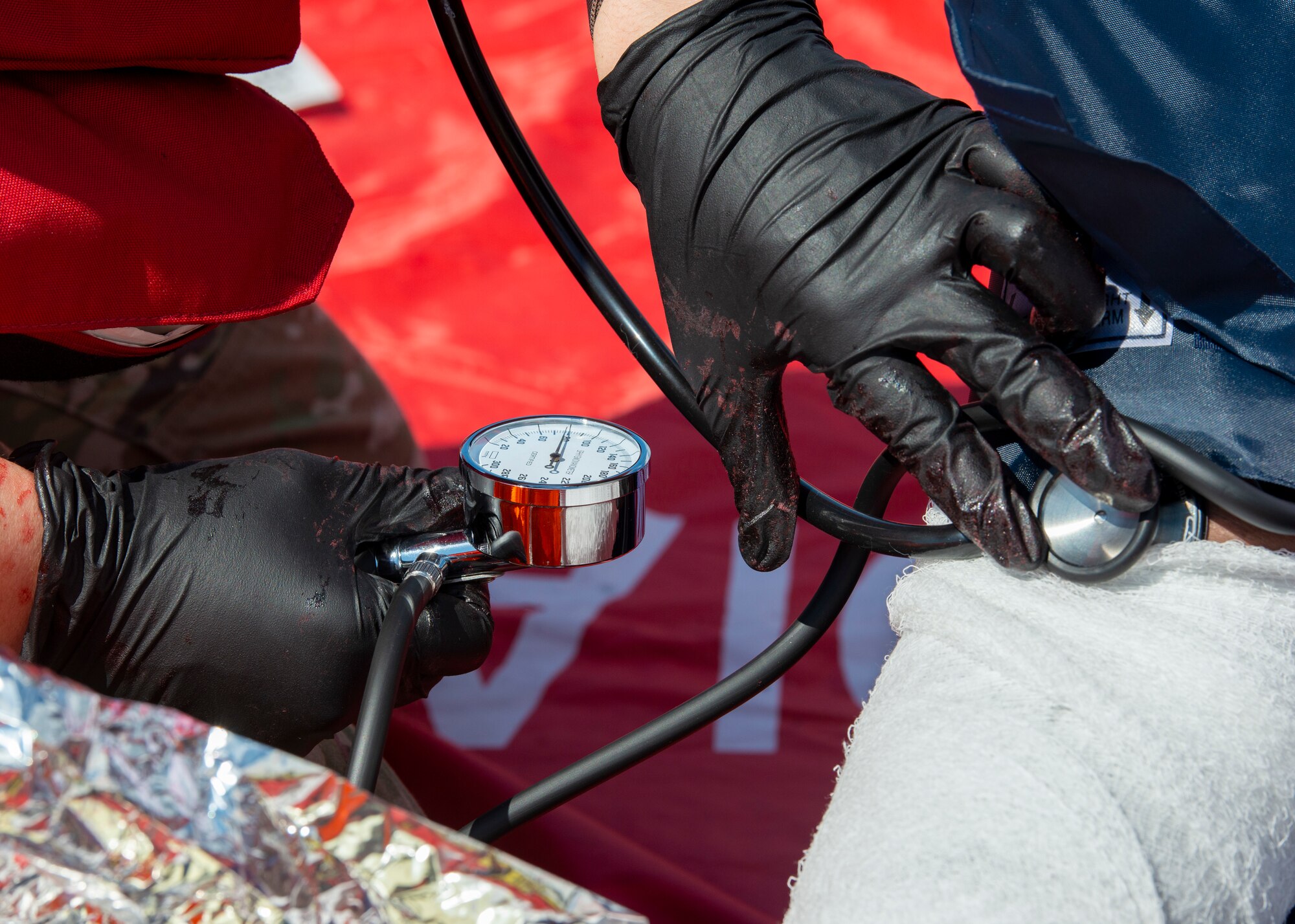 A 6th Medical Group emergency responder places a stethoscope on a simulated injured volunteer’s arm during training exercise Ready EAGLE at MacDill Air Force Base, Fla., Feb. 25, 2021. The blood and injuries in this exercise were created using moulage techniques and are not real. (U.S. Air Force photograph by Airman 1st Class David D. McLoney)