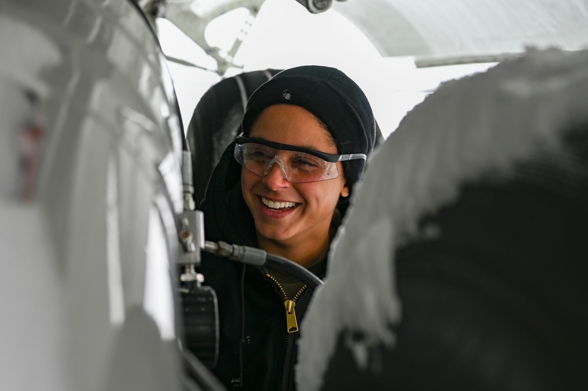 Senior Airman Kendra Ancell, hydraulics technician with the 911th Aircraft Maintenance Squadron, shares a laugh during routine maintenance on a C-17 Globemaster III landing gear strut at the Pittsburgh International Airport Air Reserve Station, Pennsylvania, Feb. 1, 2021.