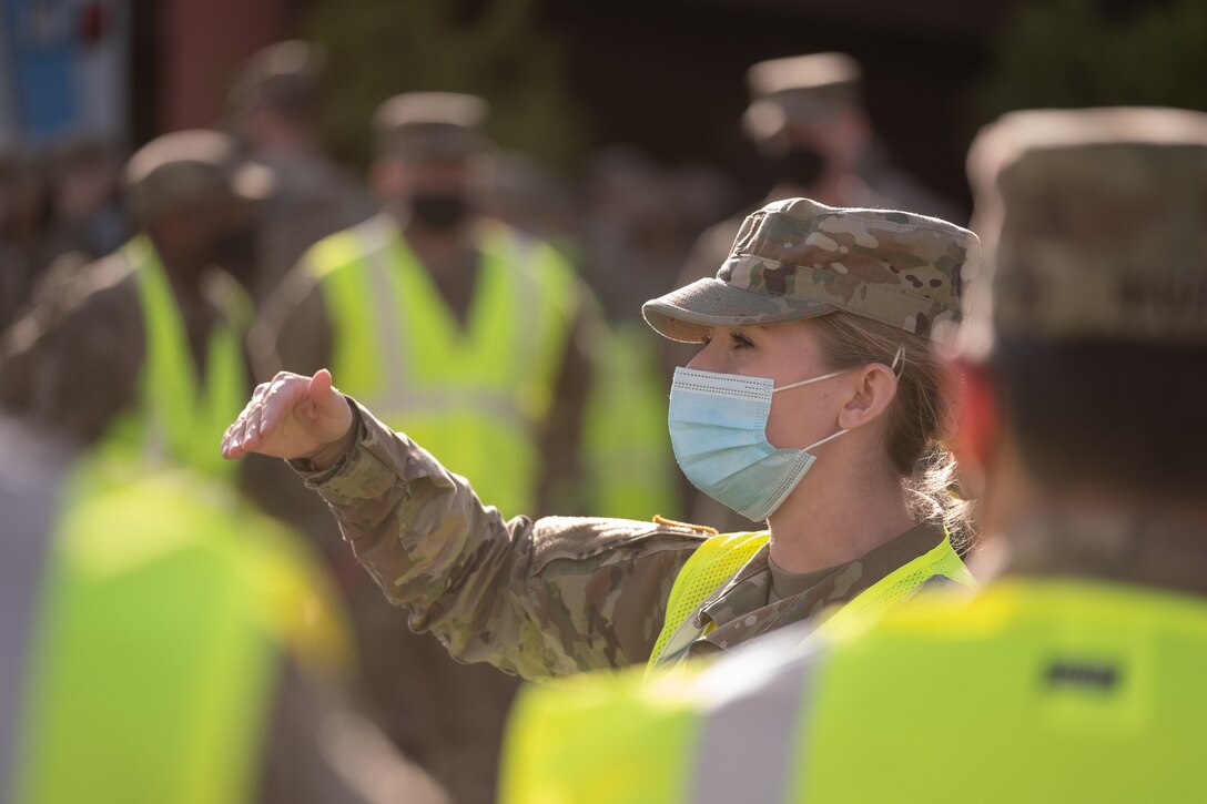 A nurse speaks to soldiers.