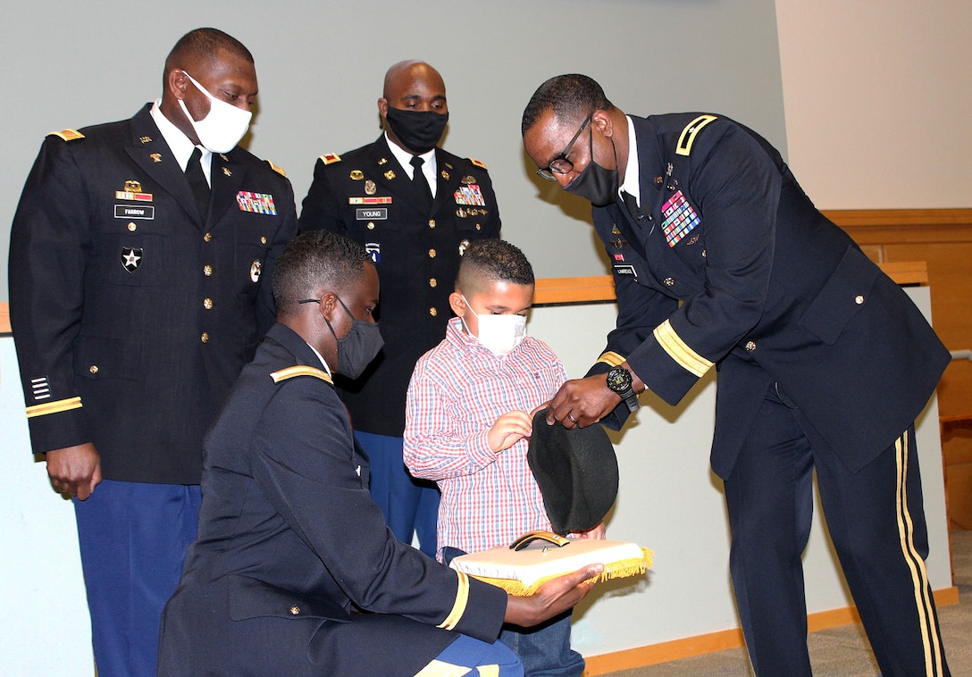 A group of men gather during an Army promotion ceremony.