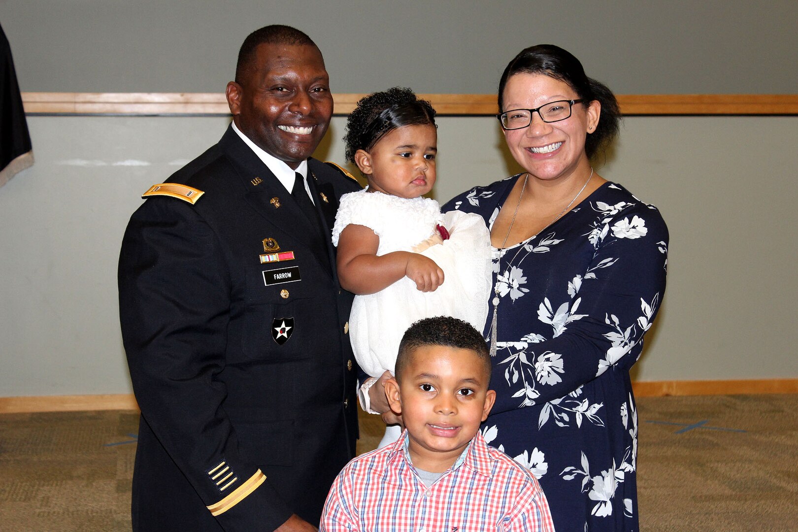 A family poses together after an Army ceremony.