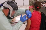 Puerto Rico National Guard Sgt. José Rodríguez administers a COVID-19 vaccine in the PRNG vaccination center in Caguas, Puerto Rico, March 1, 2021, using new personal protection equipment.