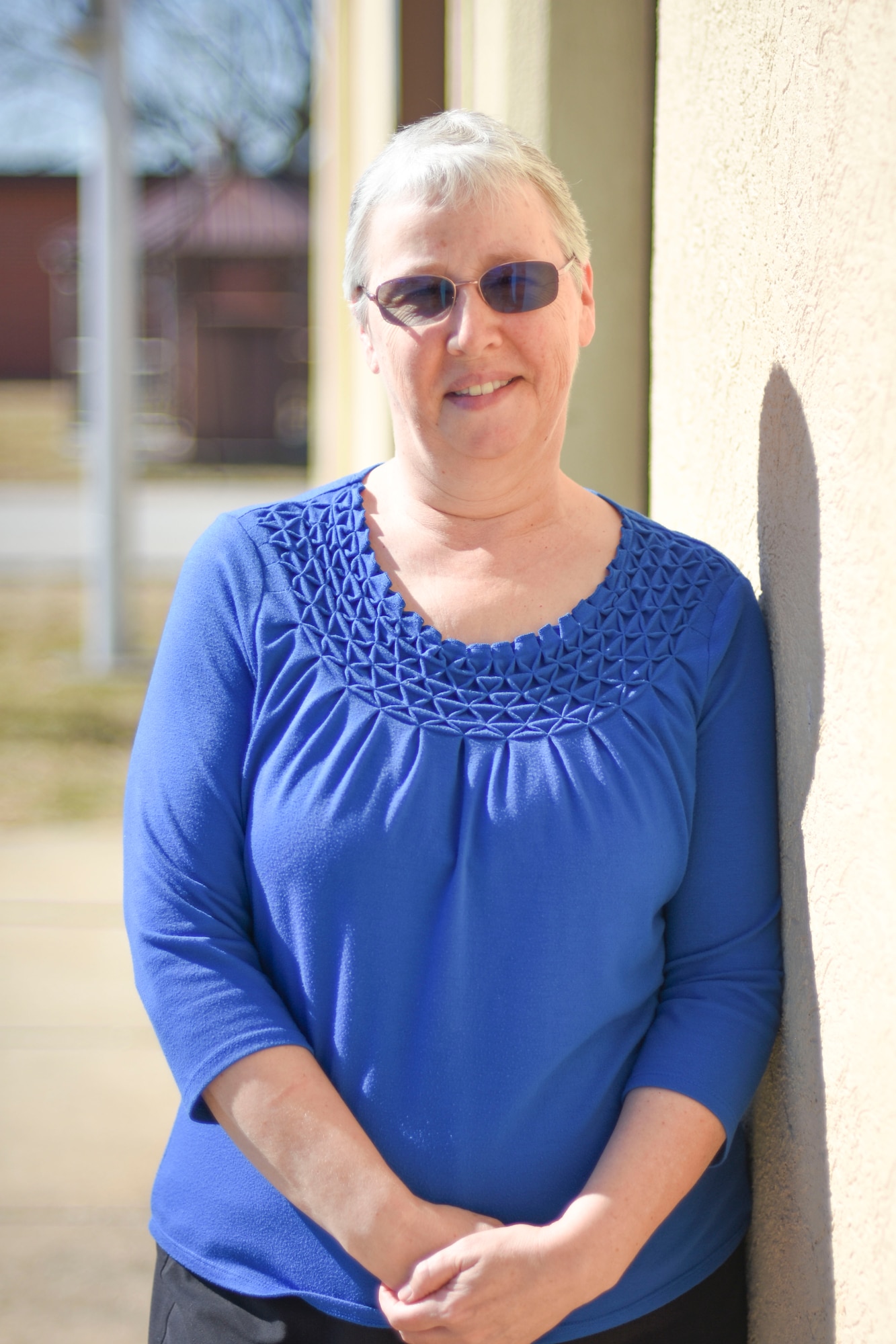Carol Ameline poses next to a wall.