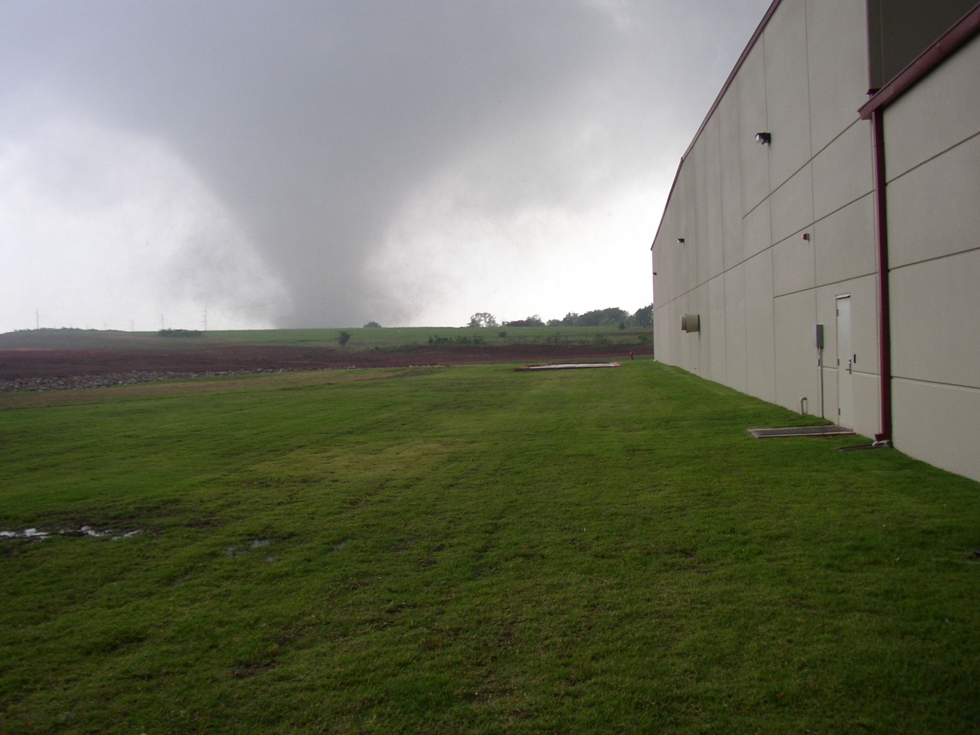 Tornado funnel on the horizon with building in foreground