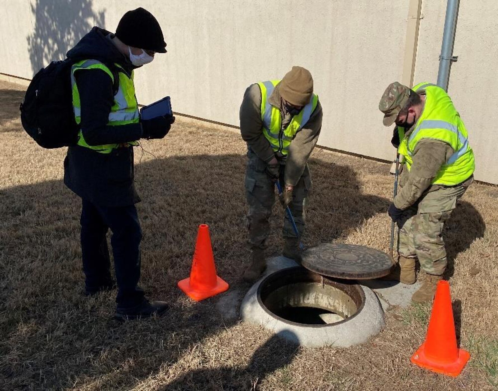 Airmen install a manhole cover.