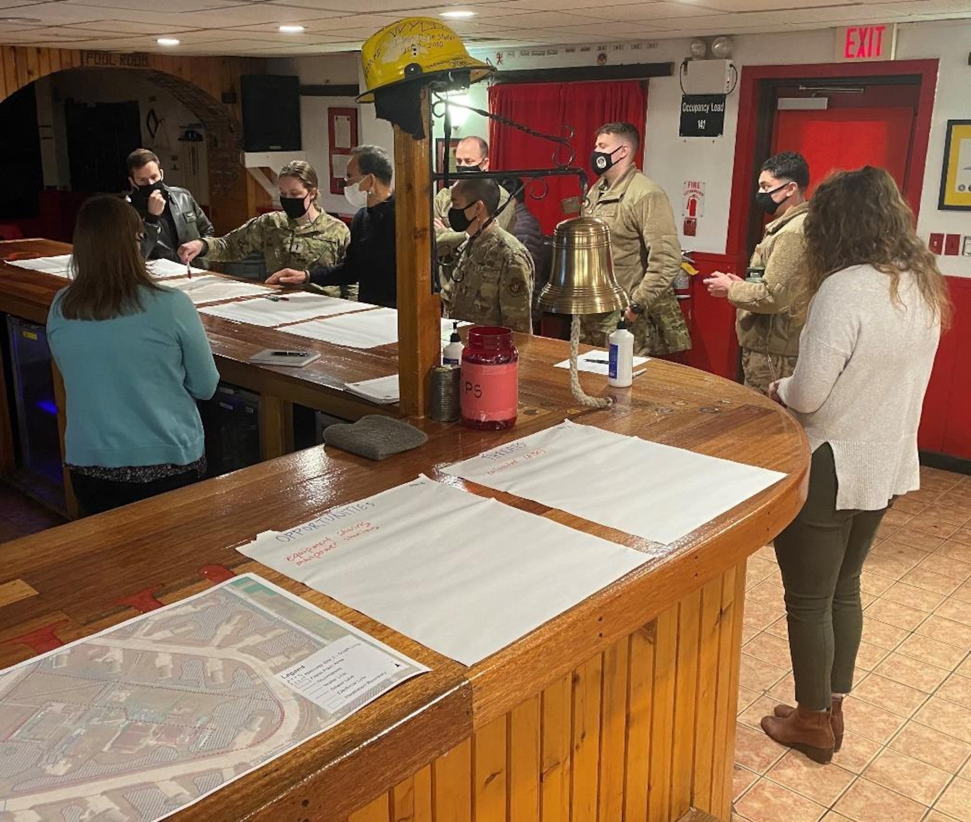 Airmen and contractors analyze a facility.