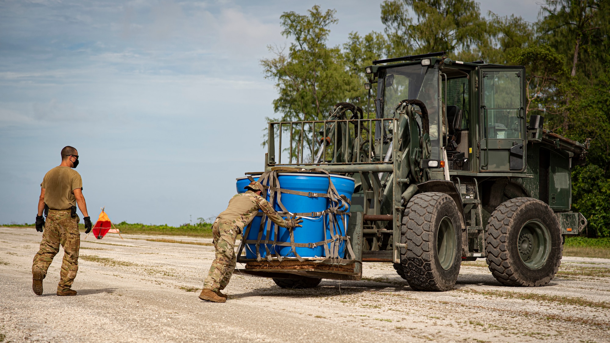 U.S. Air Force Staff Sgt. Vincent Simmons, 36th Contingency Response Squadron aerial port journeyman, secures an airdroped package to a forklift during Cope North 21, Feb. 10, 2021, on Angaur, Palau.