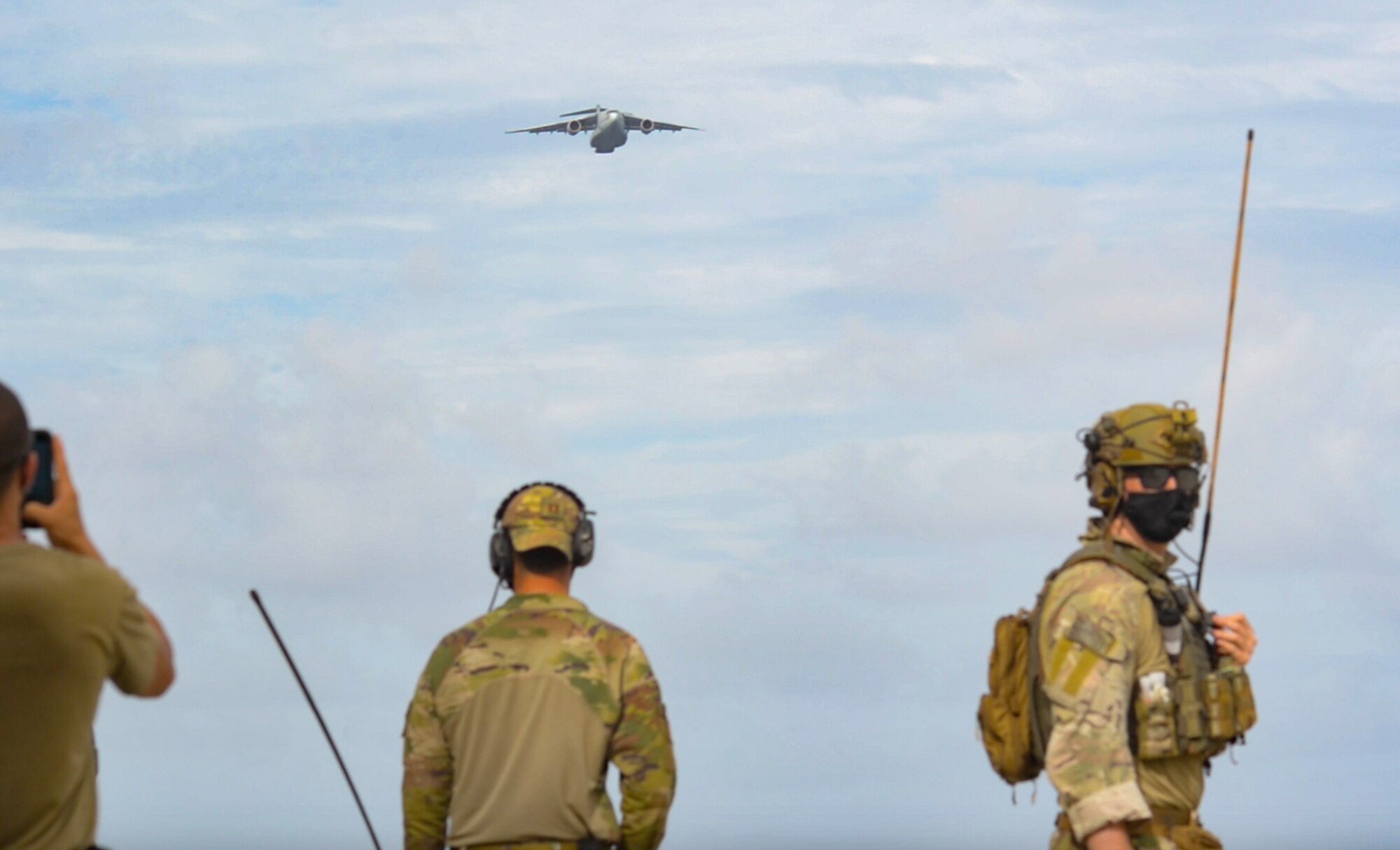 Members of the 36th Contingency Response Group watch as a Koku-Jieitai Kawasaki C-2, assigned to the 403rd Squadron from Miho Air Base, approaches for an airdrop during Cope North 21, Feb. 10, 2021, on Angaur, Palau.
