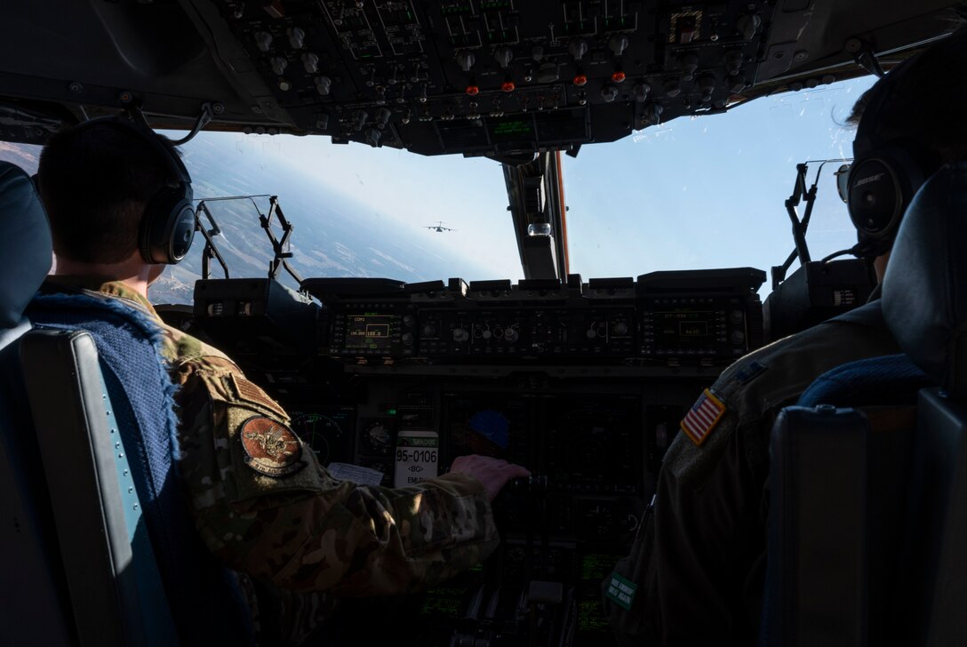 Capt. Tim Wilson, left, 8th Airlift Squadron pilot, and Capt. Evan Maes, 8th AS copilot, fly a C-17 Globemaster III assigned to the 62nd Airlift Wing, Joint Base Lewis-McChord, Wash., in a formation flight during Exercise Predictable Iron at Pope Army Airfield, Fort Bragg, N.C., Feb. 25, 2021. The exercise provided the opportunity for the U.S. Air Force and U.S. Army to strengthen their skill sets together and accomplish the Department of Defense’s mission to provide combat-credible military forces.
